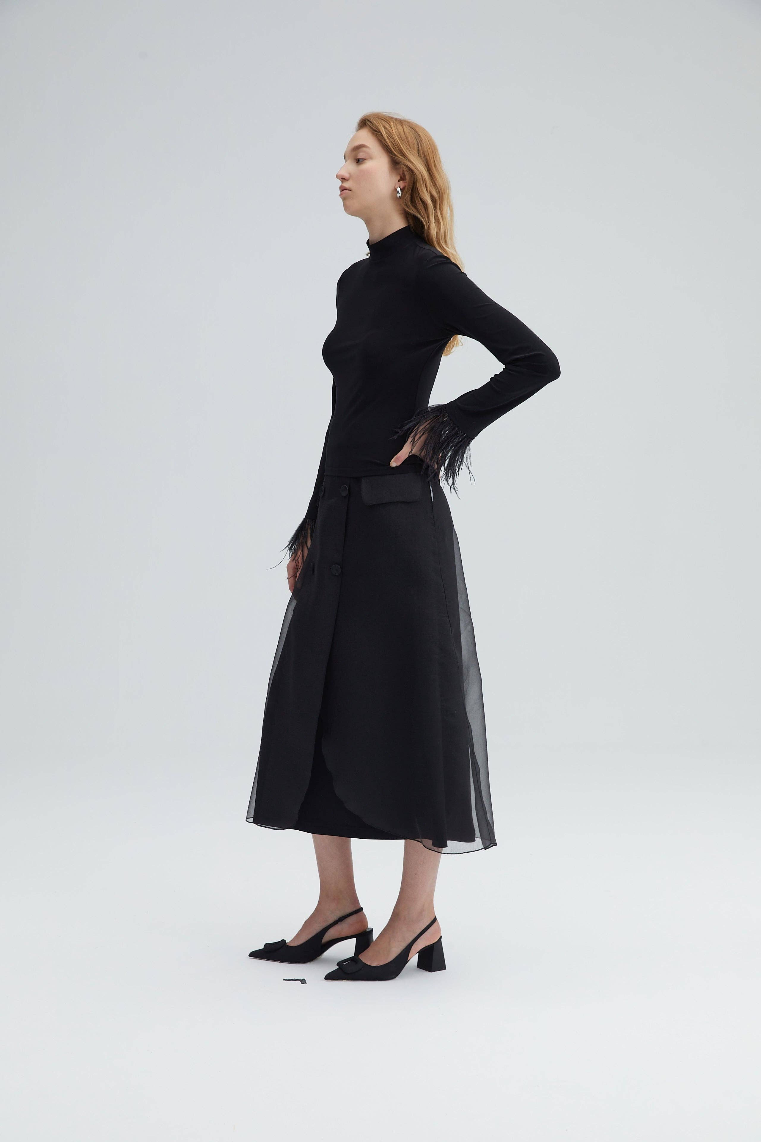 HAUT À COL MONTANT AVEC MANCHETTES EN PLUMES – NOIR ÉLÉGANT